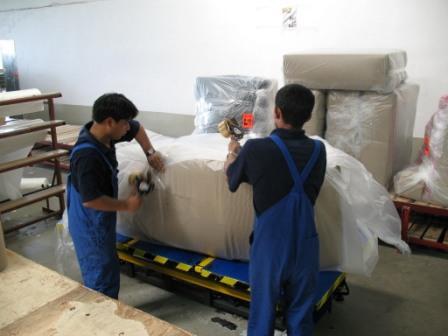 Nepali Uphosleters packing sofas at furniture Helvetica furniture factory in Poland